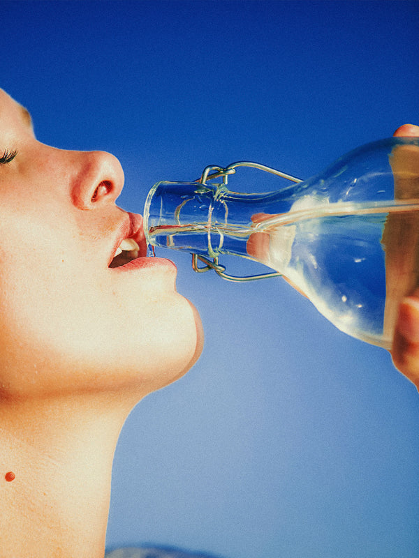 woman drinking from a glass bottle edited with Fujifilm Fortia SP50 film emulation preset — hyper-saturated vivid colours