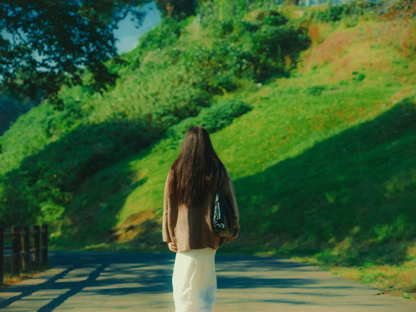woman walking on a sunlit road showing Fujifilm Fortia SP50 film emulation look in Lightroom