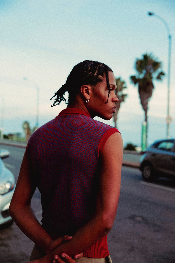 Person wearing a red sleeveless top standing on a street with palm trees in the background - Kodak Portra 400 film emulation preset by PresetVault